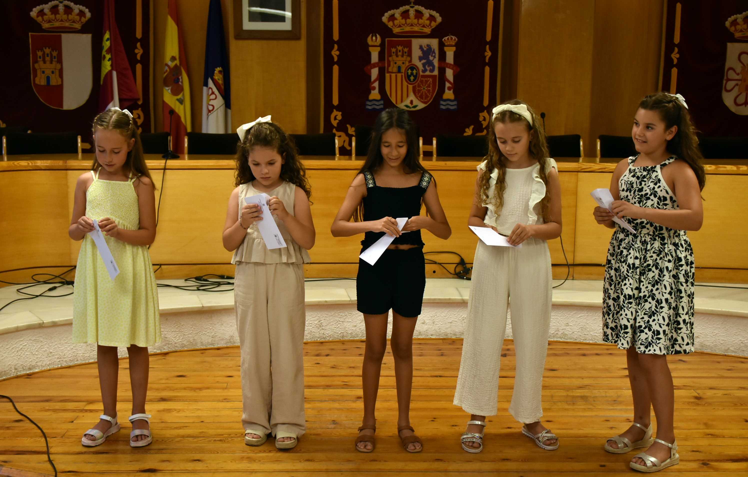 Damas infantiles abriendo los sobres del sorteo
