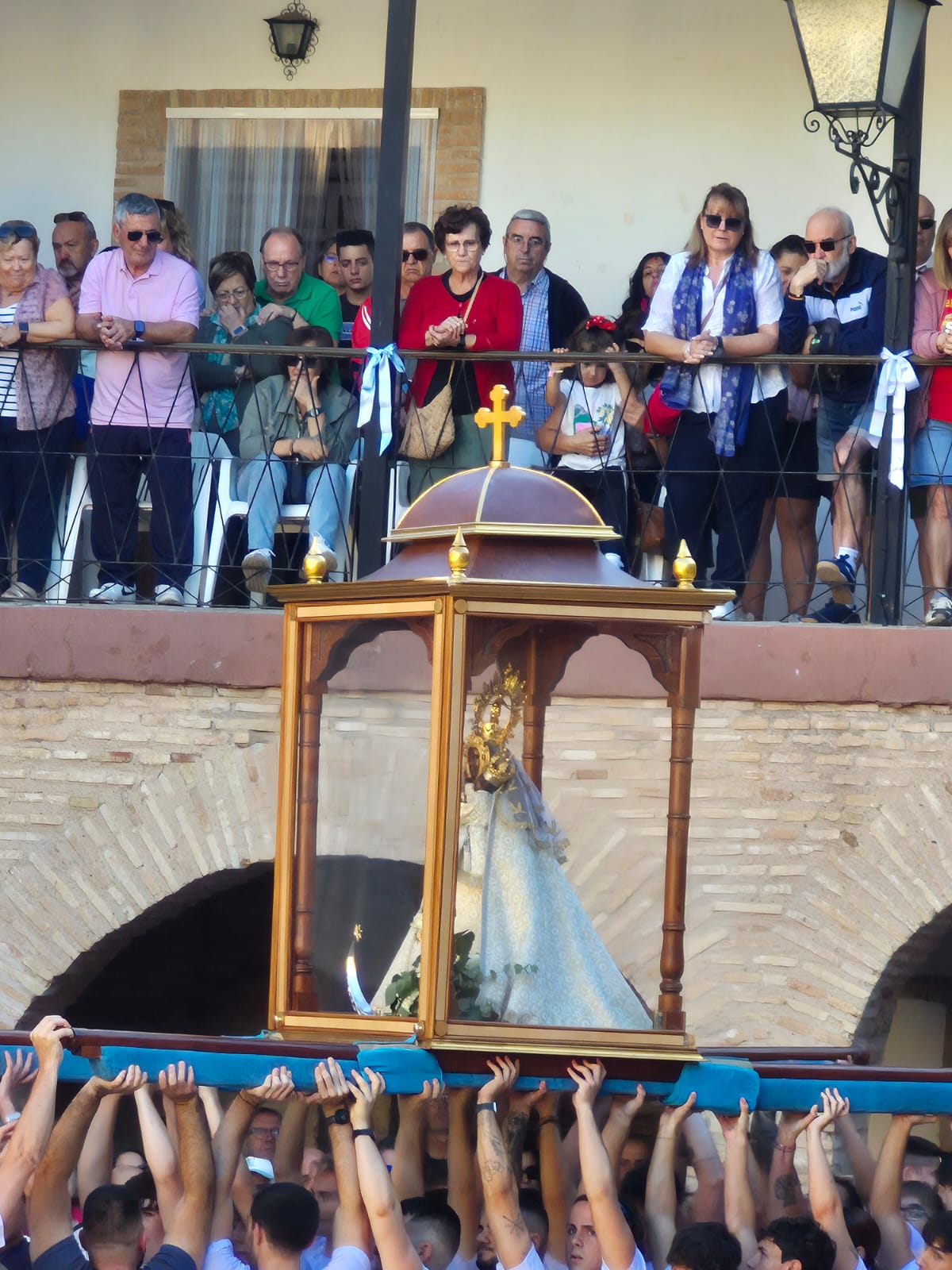 Los mozos alzando la Virgen en el patio interior.
