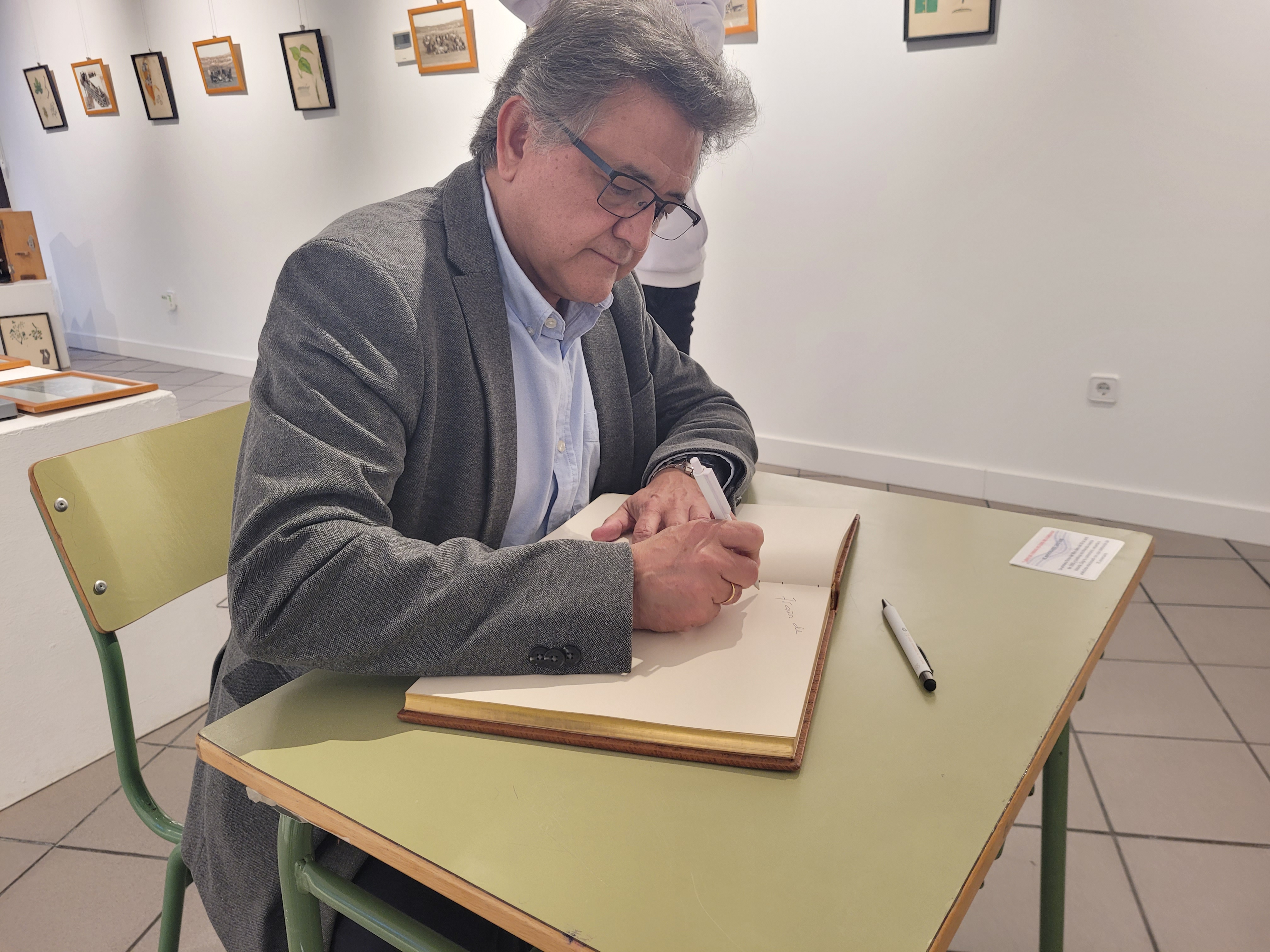 El alcalde firmó en el libro de visitas de la exposición.