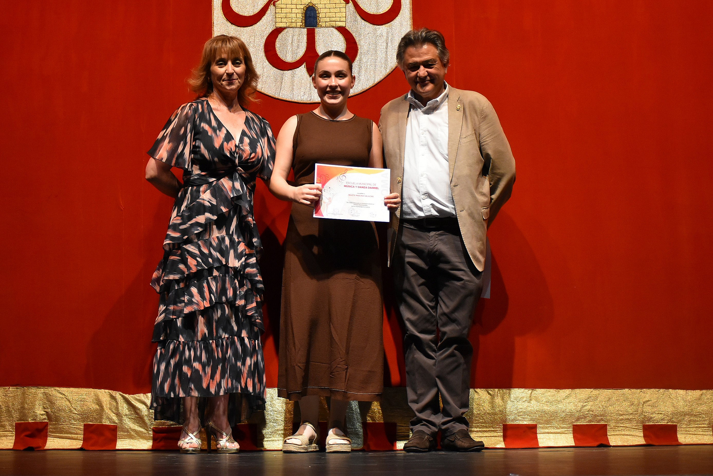Paqui Bravo junto al alcalde en la entrega de diplomas del festival de fin de curso de 2025.