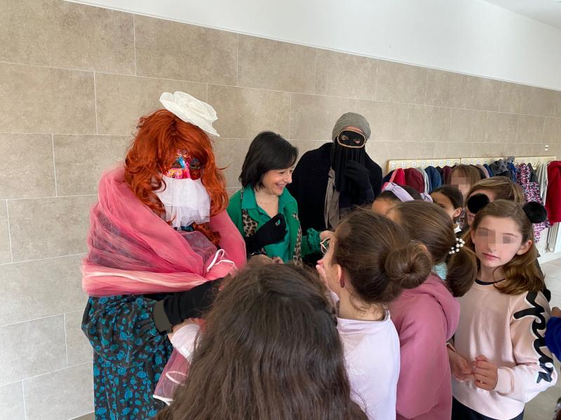 La concejala de Festejos, Alicia Loro, junto a dos máscaras guarronas y escolares del C.P. San Isidro, este jueves.