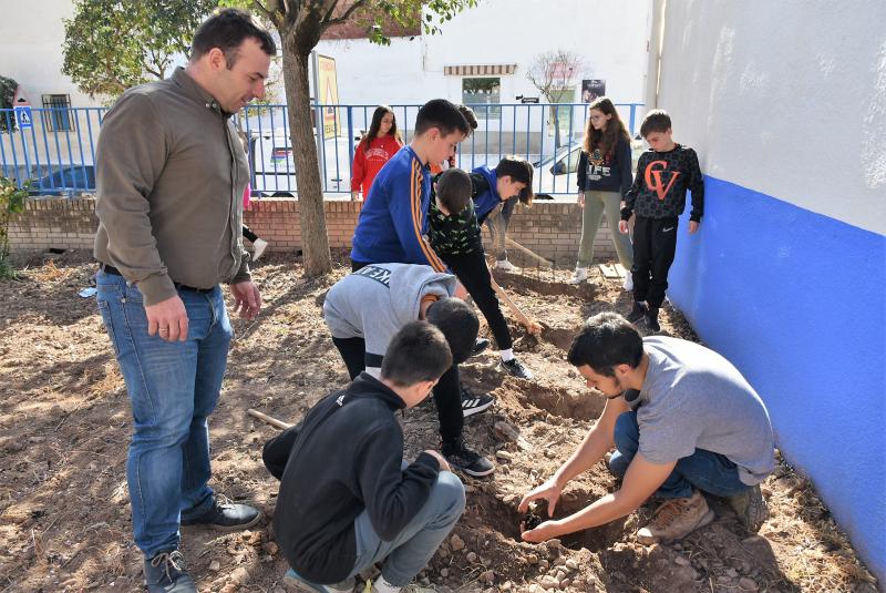 Javier Fisac junto a los alumnos en la plantación de hoy martes en el huerto escolar.
