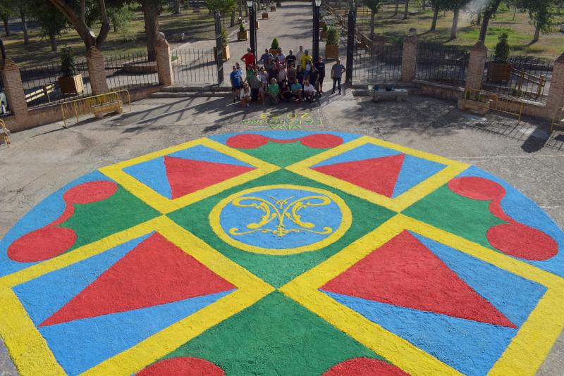 Voluntarios e integrantes de la Hermandad junto con la alfombra floral