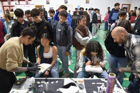 Alumnos en el stand de tatuadores